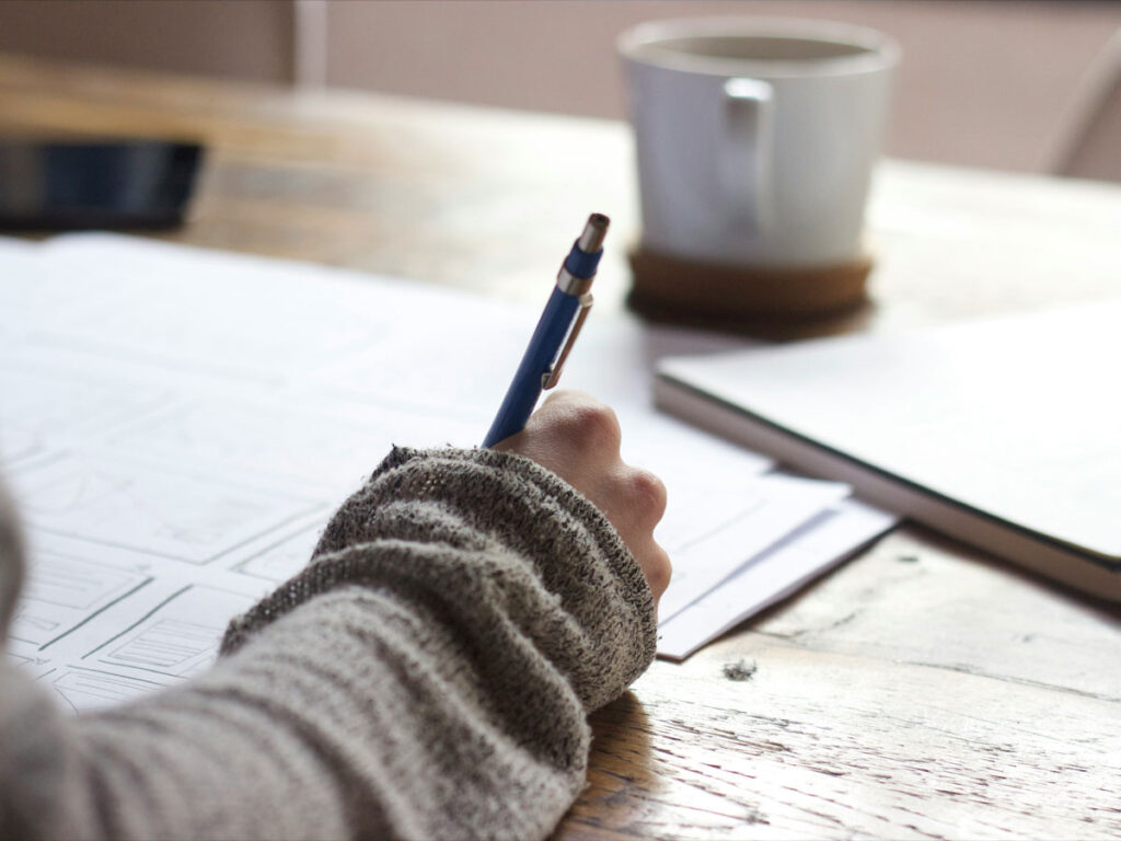 Psychologist writing notes on a pad on a desk